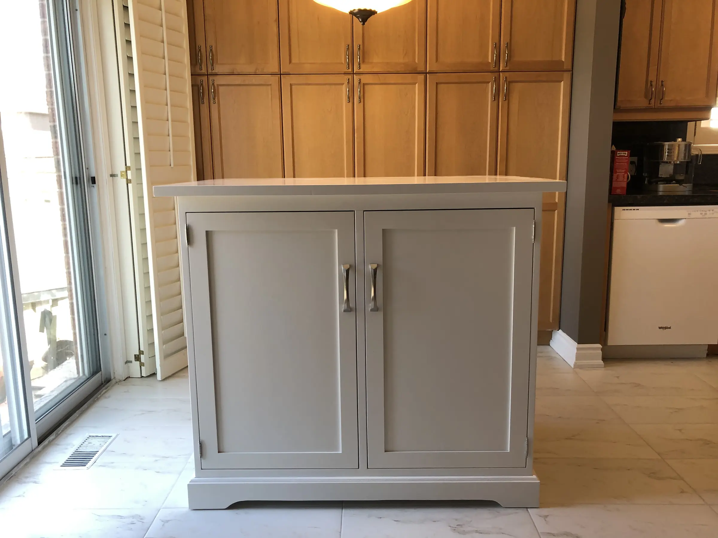 Painted custom solid wood storage cabinet installed in a kitchen