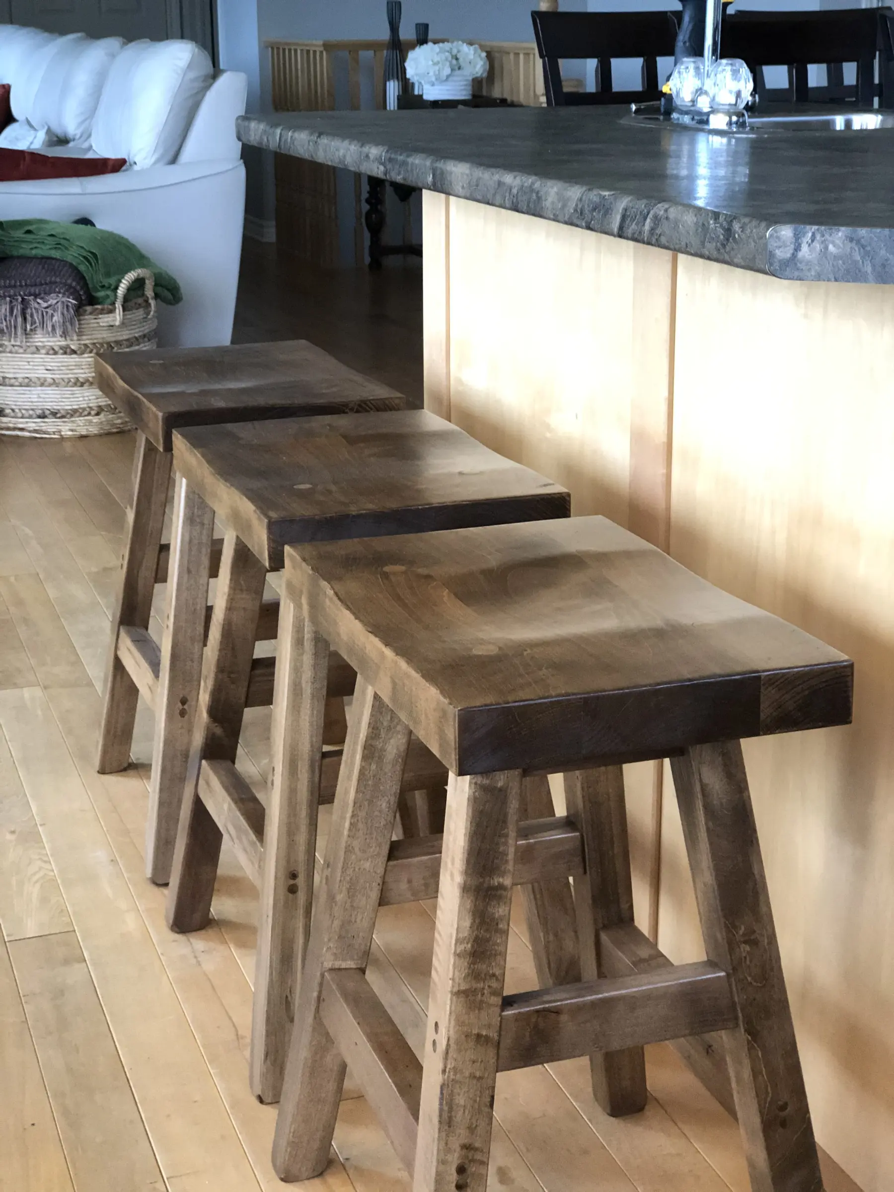 Custom rustic solid wood saddle stools installed at a kitchen island