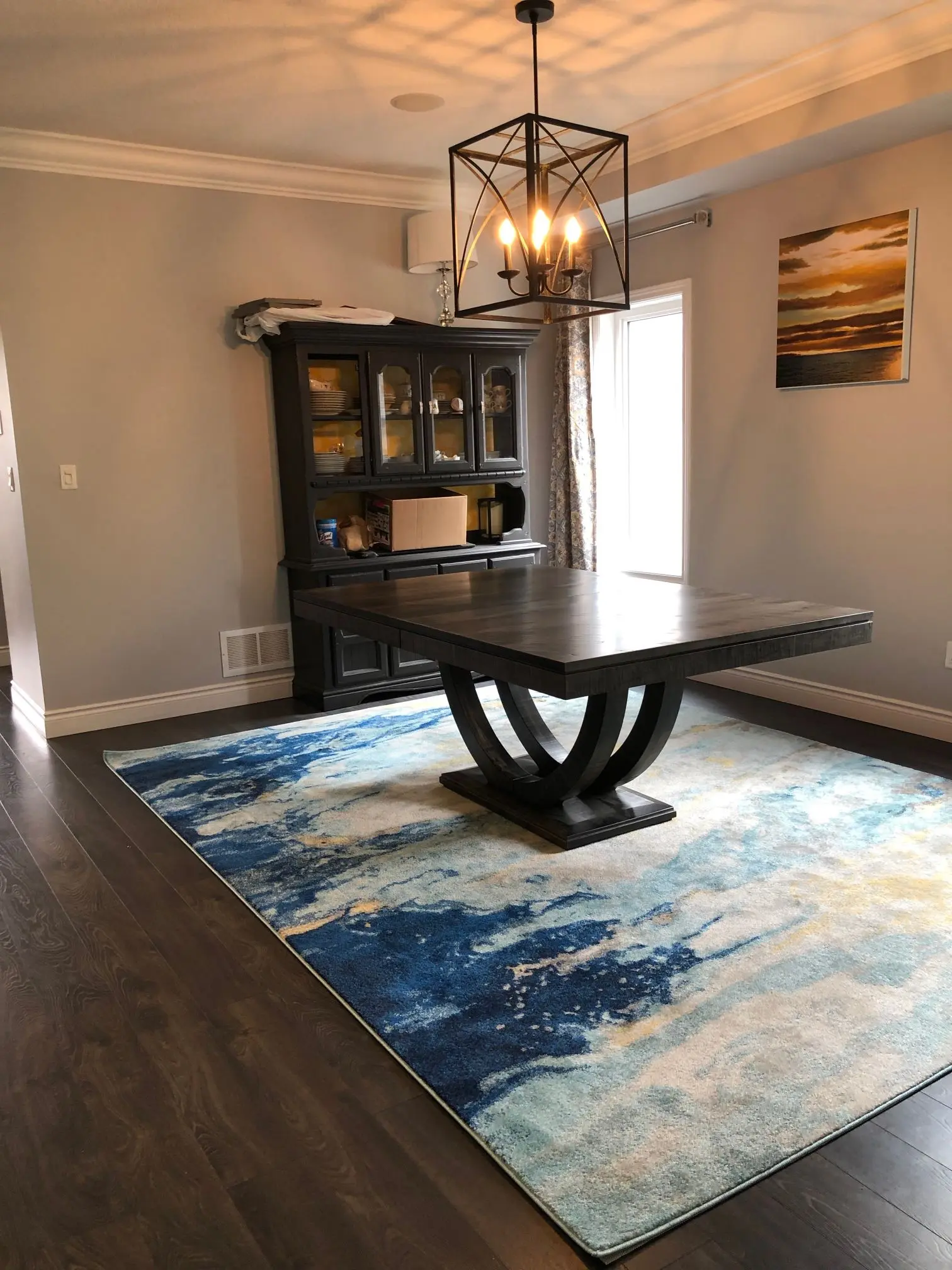 Custom solid wood dining table and glass-door hutch in a finished dining room
