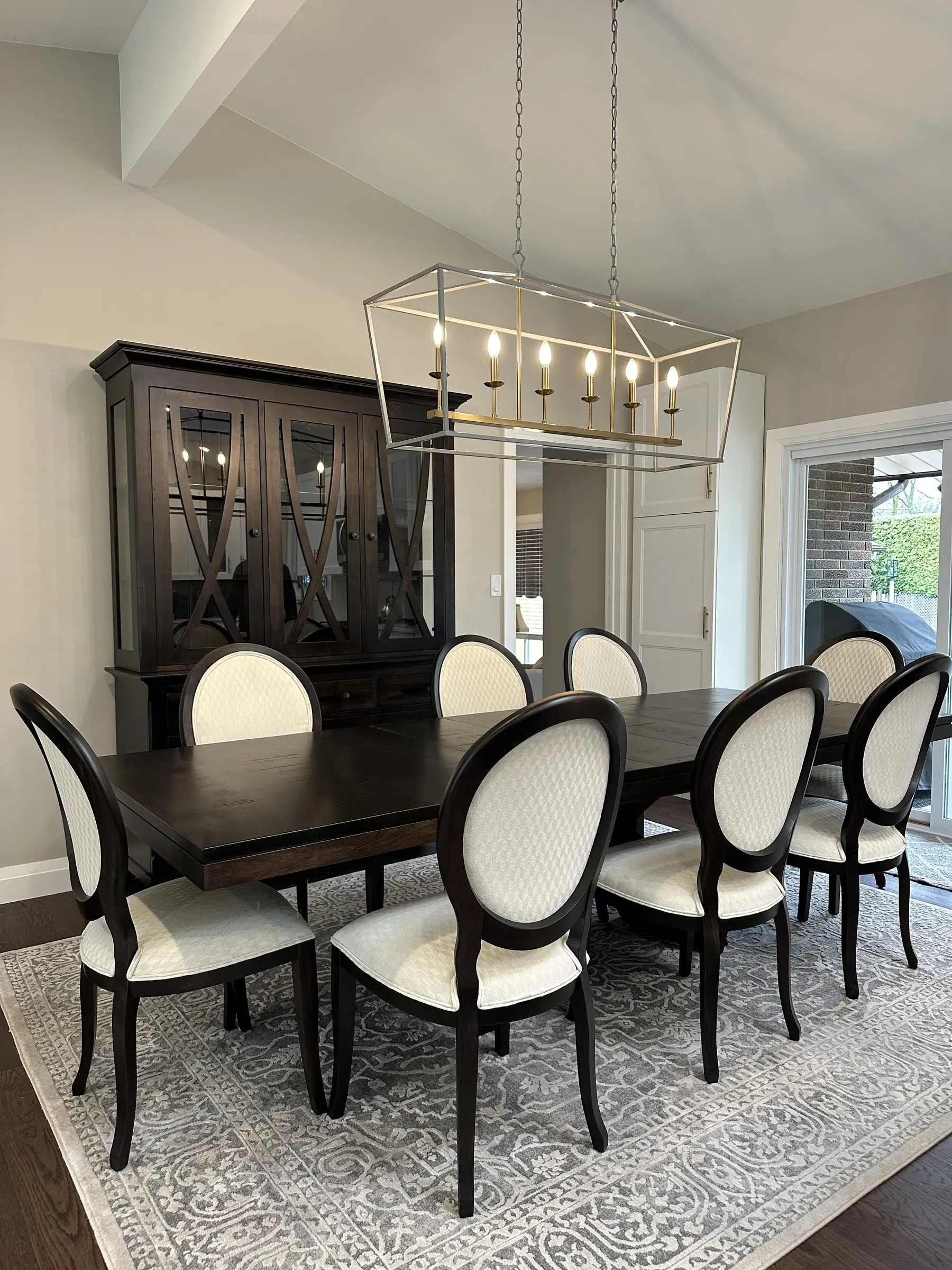 Custom dark wood dining table with upholstered oval-back chairs