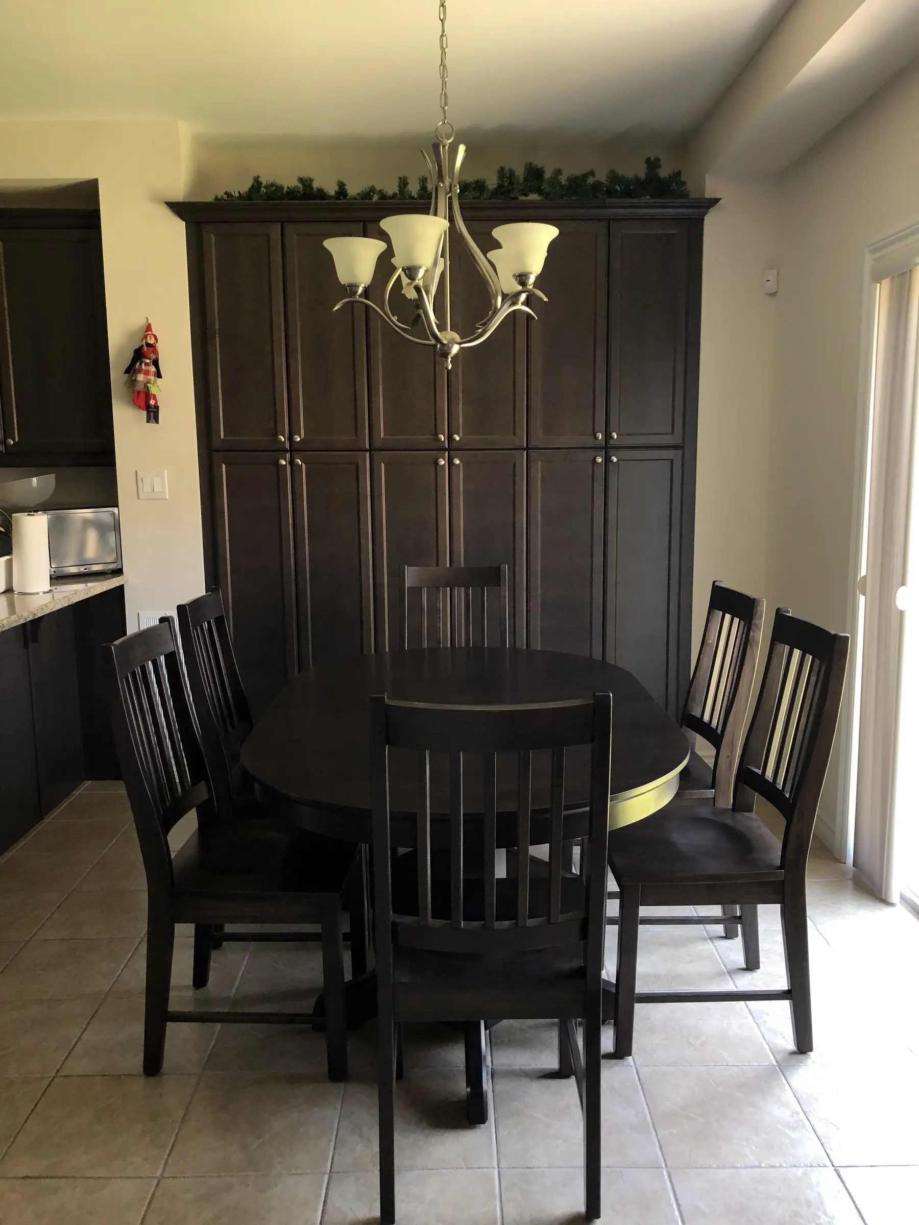 Custom round solid wood dining table with matching chairs and hutch