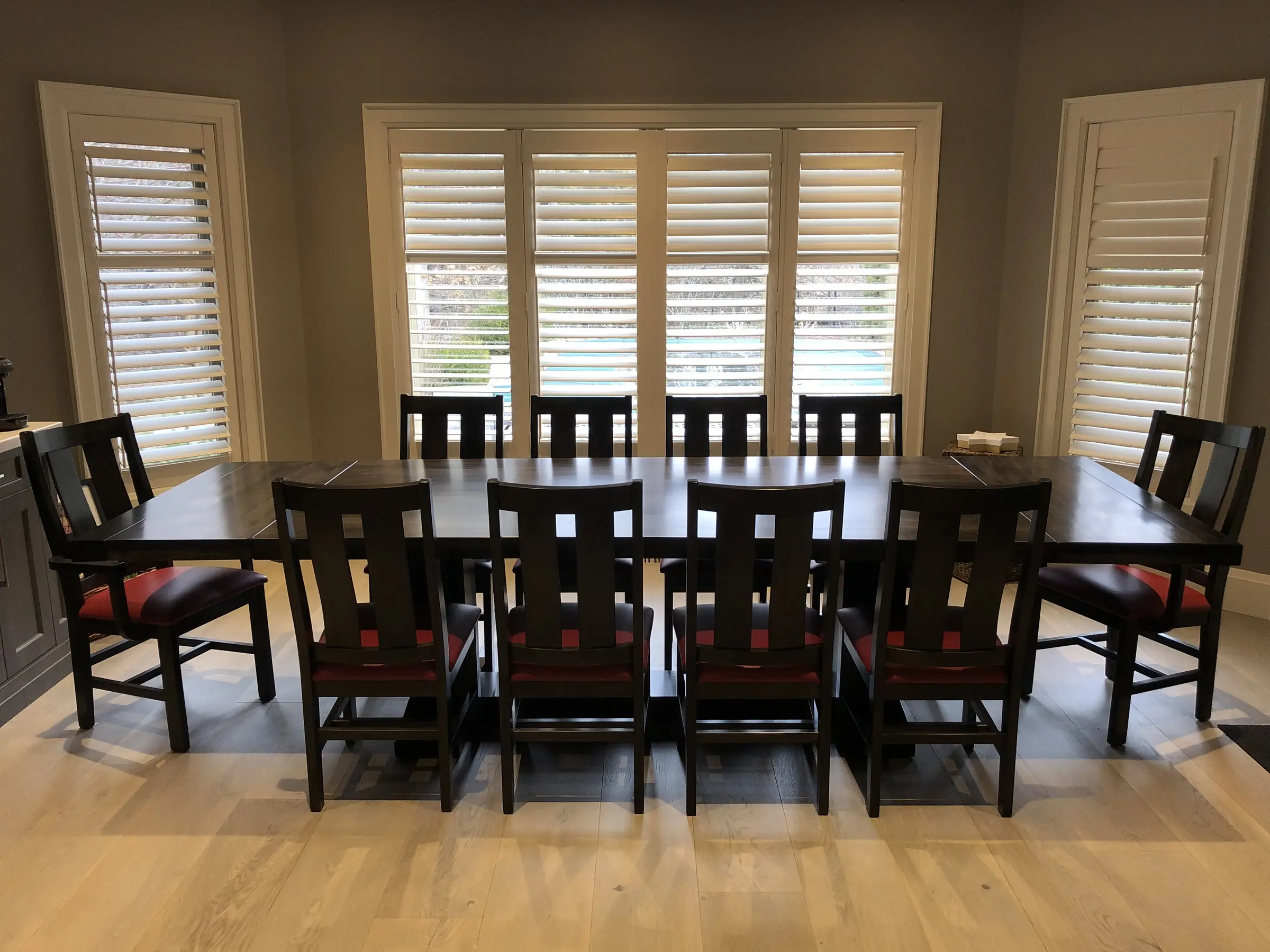 Large custom solid wood dining table and chair set in a bright dining room
