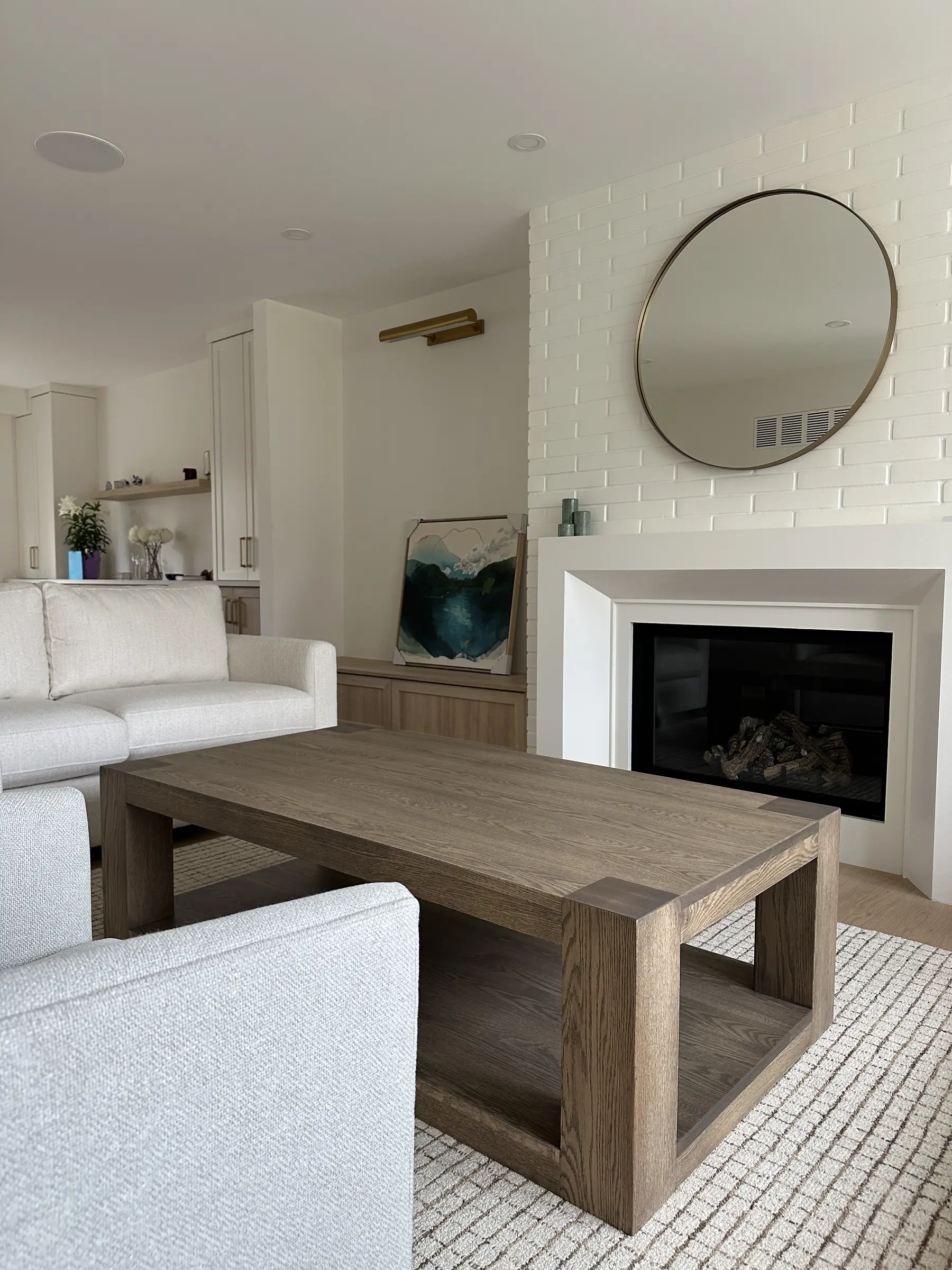 Modern rectangular solid wood coffee table beside a white fireplace