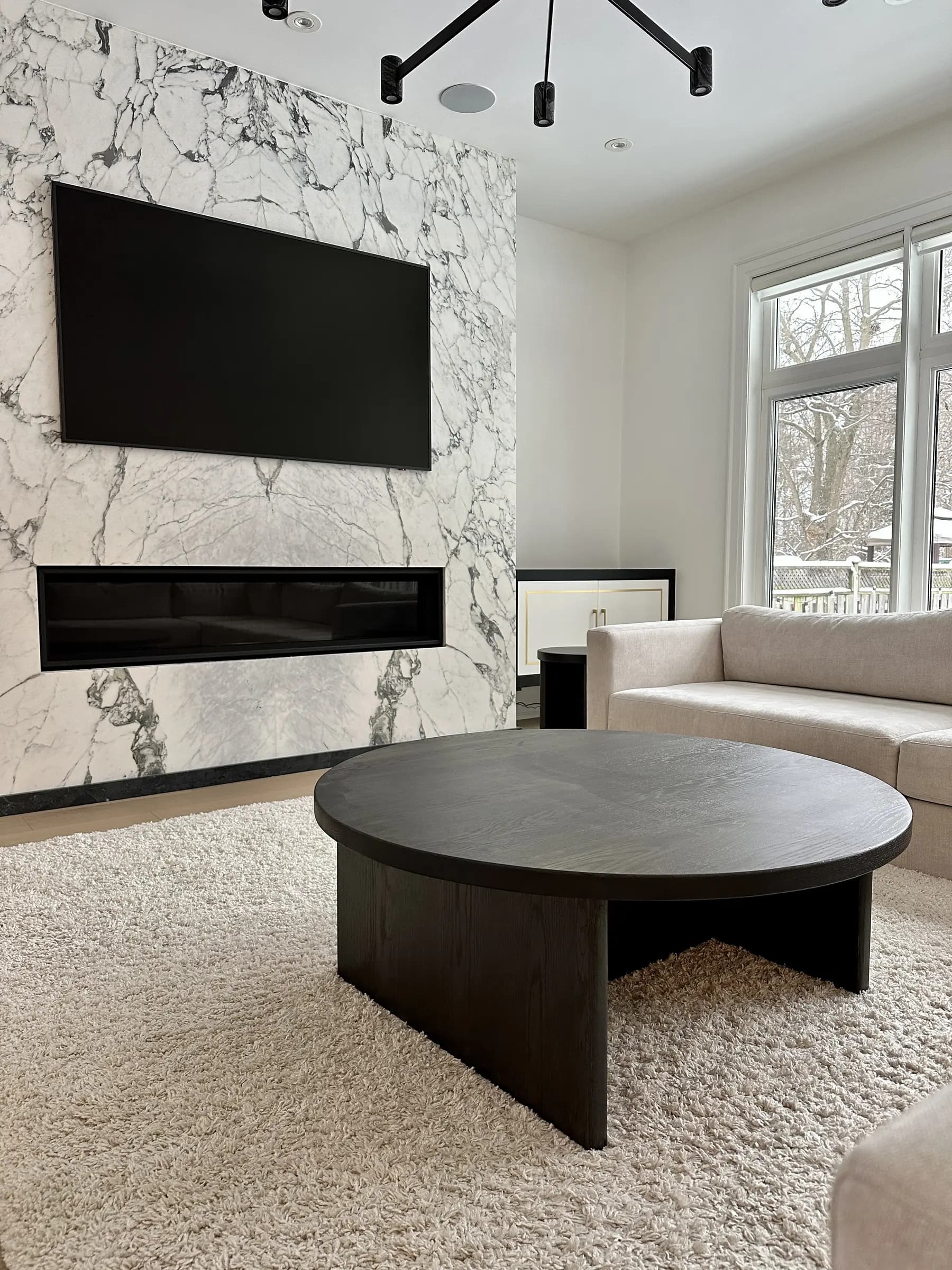 Round solid wood coffee table in a bright contemporary living room